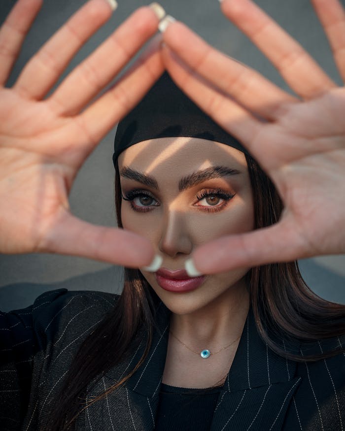 Young Woman Holding Her Hands in a Triangle Shape in front of Her Face